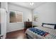 A cozy bedroom showcases hardwood floors, a ceiling fan, and two bright windows at 6827 W El Cortez Pl, Peoria, AZ 85383