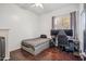 This bedroom features wood floors, a ceiling fan, and a window for natural light at 6827 W El Cortez Pl, Peoria, AZ 85383