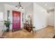 Welcoming entryway with a red door, tile flooring, and stylish decor at 6827 W El Cortez Pl, Peoria, AZ 85383
