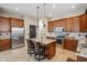Open concept kitchen featuring granite countertops, center island with seating, and stainless appliances at 6827 W El Cortez Pl, Peoria, AZ 85383