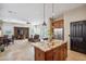 Open concept floor plan featuring kitchen, dining, and living area with fireplace and tile flooring at 6827 W El Cortez Pl, Peoria, AZ 85383
