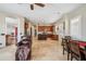 Open living room and kitchen with center island, stainless appliances, and travertine tile flooring at 6827 W El Cortez Pl, Peoria, AZ 85383