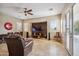 Inviting living room with stone accent wall, media console, and travertine tile flooring at 6827 W El Cortez Pl, Peoria, AZ 85383