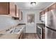 Well-lit kitchen features stainless steel appliances, wood cabinets, and ample counter space, creating a functional cooking area at 747 S Extension Rd # 113, Mesa, AZ 85210
