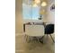 Simple dining area with a glass table and chairs, illuminated by a modern light fixture at 7625 E Camelback Rd # B241, Scottsdale, AZ 85251