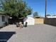 Backyard features a gravel area, mature tree, shed, and seating with fire pit at 7802 E Hubbell St, Scottsdale, AZ 85257