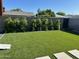 Backyard with lush artificial turf, landscaping, and a concrete block fence at 7802 E Hubbell St, Scottsdale, AZ 85257