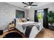 Bedroom with hardwood floors, patterned accent wall, ceiling fan, and sliding door closet at 7802 E Hubbell St, Scottsdale, AZ 85257