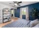 Cozy bedroom featuring hardwood floors, blue accent wall, and a modern bookshelf at 7802 E Hubbell St, Scottsdale, AZ 85257