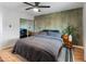 Modern bedroom with hardwood floors, accent wall, ceiling fan, and sliding door closet at 7802 E Hubbell St, Scottsdale, AZ 85257