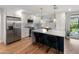 Bright kitchen featuring an island with bar seating, stainless steel appliances, and white cabinetry at 7802 E Hubbell St, Scottsdale, AZ 85257
