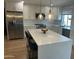 Bright, modern kitchen featuring white cabinets, stainless steel appliances, an island, and stylish pendant lighting at 7802 E Hubbell St, Scottsdale, AZ 85257