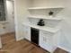Stylish wet bar area with white cabinets, quartz countertops, and a built-in wine fridge at 7802 E Hubbell St, Scottsdale, AZ 85257