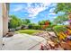Well-maintained backyard featuring a concrete patio, lush lawn, and vibrant flowerbeds, ideal for relaxation at 8009 W Salter Dr, Peoria, AZ 85382