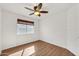 Bedroom featuring laminate floors, chair rail, window, and ceiling fan at 8009 W Salter Dr, Peoria, AZ 85382