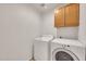 Laundry room featuring side-by-side washer and dryer with a storage cabinet above at 8009 W Salter Dr, Peoria, AZ 85382