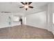 Bright living room featuring tile floors, a ceiling fan, and an open layout to the kitchen at 8009 W Salter Dr, Peoria, AZ 85382