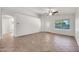 Bright living room featuring tile floors, a ceiling fan, and a front door at 8009 W Salter Dr, Peoria, AZ 85382