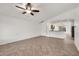 Bright living room featuring tile floors, a ceiling fan, and an open layout to the kitchen at 8009 W Salter Dr, Peoria, AZ 85382