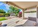 Covered patio offers a shaded outdoor living space with string lights and views of the beautifully landscaped backyard at 8009 W Salter Dr, Peoria, AZ 85382