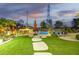 Beautiful backyard featuring a pool, dining area, lush landscaping, and an outdoor entertainment space at 8132 W Hatfield Rd, Peoria, AZ 85383