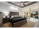 Spacious primary bedroom with plush carpet, ceiling fan, and access to the outdoors at 8132 W Hatfield Rd, Peoria, AZ 85383