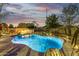 Sparkling backyard pool with waterfall features, landscape lighting, and a patio with firepit at 8132 W Hatfield Rd, Peoria, AZ 85383