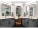 Dual sink vanity featuring gray cabinets, white countertops, and modern fixtures at 8132 W Hatfield Rd, Peoria, AZ 85383