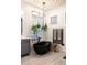 Modern bathroom with a black standalone tub, grey vanity, and glass block window at 8132 W Hatfield Rd, Peoria, AZ 85383