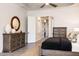 Spacious bedroom features dual dressers and a dark wooden bed frame, all elegantly furnished at 8132 W Hatfield Rd, Peoria, AZ 85383