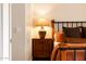 Nightstand lamp illuminates a charming bedroom showcasing a wooden nightstand with drawers and a rustic bed at 8132 W Hatfield Rd, Peoria, AZ 85383