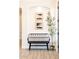 Inviting entryway features a decorative bench with artistic wall decor and a potted olive tree at 8132 W Hatfield Rd, Peoria, AZ 85383