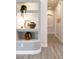 Stylish hallway featuring illuminated decorative wall niches and modern gray plank flooring at 8132 W Hatfield Rd, Peoria, AZ 85383