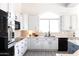 Modern kitchen with white cabinets, dark hardware and great natural light at 8132 W Hatfield Rd, Peoria, AZ 85383