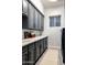 Laundry room with grey cabinets, quartz countertop, and a modern washer and dryer at 8132 W Hatfield Rd, Peoria, AZ 85383
