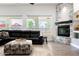 Bright living room with a stone fireplace, black sofa and views to the outside patio at 8132 W Hatfield Rd, Peoria, AZ 85383