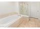 Large bathtub with marble tile surround and glass-enclosed shower, providing a spa-like experience at 8270 N Hayden Rd # 2041, Scottsdale, AZ 85258