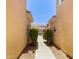 Exterior shot of a walkway between buildings, lined with lush green bushes at 8270 N Hayden Rd # 2041, Scottsdale, AZ 85258