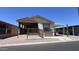 Charming home featuring a covered porch and carport, surrounded by easy-care desert landscaping at 9333 E University Dr # 57, Mesa, AZ 85207