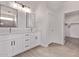 Modern bathroom with dual sinks, sleek white cabinets, and a walk-in closet providing ample storage at 9429 W Sandstone Mountain Dr, Casa Grande, AZ 85194