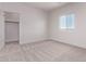 Light-filled bedroom with neutral carpeting and an adjacent walk-in closet at 9429 W Sandstone Mountain Dr, Casa Grande, AZ 85194