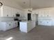 Kitchen featuring quartz countertops, modern appliances, white cabinets, and an island with a sink at 9429 W Sandstone Mountain Dr, Casa Grande, AZ 85194