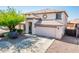 Inviting two-story home featuring a well-manicured front yard, charming architectural details, and an attached two-car garage at 9735 W Kirby Ave, Tolleson, AZ 85353