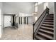 Bright living room with soaring ceilings, a staircase with dark wood banister, and gray walls creating a modern aesthetic at 9735 W Kirby Ave, Tolleson, AZ 85353