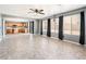 Spacious living room open to the kitchen with neutral paint, tile floors, and large windows providing natural light at 9735 W Kirby Ave, Tolleson, AZ 85353