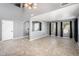 Open-concept living area featuring high ceilings, neutral gray walls, tile floors, and plenty of natural light from the window at 9735 W Kirby Ave, Tolleson, AZ 85353