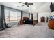 Spacious main bedroom with a ceiling fan, carpet, and large windows offering ample natural light at 9735 W Kirby Ave, Tolleson, AZ 85353