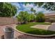 Landscaped backyard with artificial turf and a cozy fire pit area at 10722 W Irma Ln, Peoria, AZ 85373