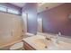 Well-lit bathroom featuring a bathtub and shower combination, a vanity with sink and mirror, and light purple painted walls at 10722 W Irma Ln, Peoria, AZ 85373