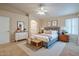Bright bedroom with a ceiling fan, a large window, and neutral decor with a white door and dresser at 10722 W Irma Ln, Peoria, AZ 85373